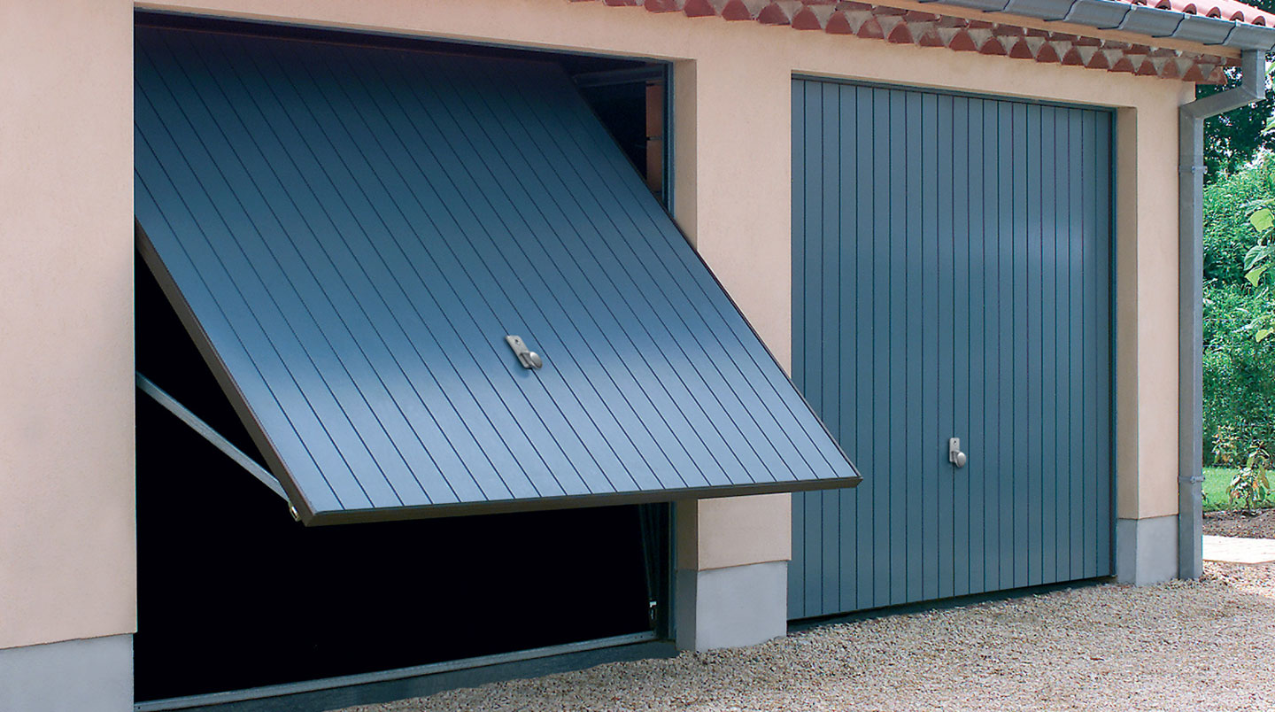 Porte de garage basculante débordante en acier galvanisé en position ouverte, vue latérale montrant le débordement extérieur de 30-40 cm caractéristique de ce système d'ouverture